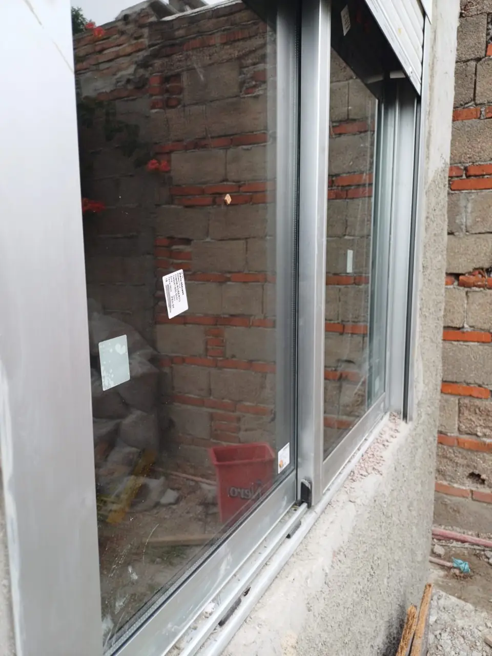 Marco de aluminio recién colocado en una pared de ladrillo
