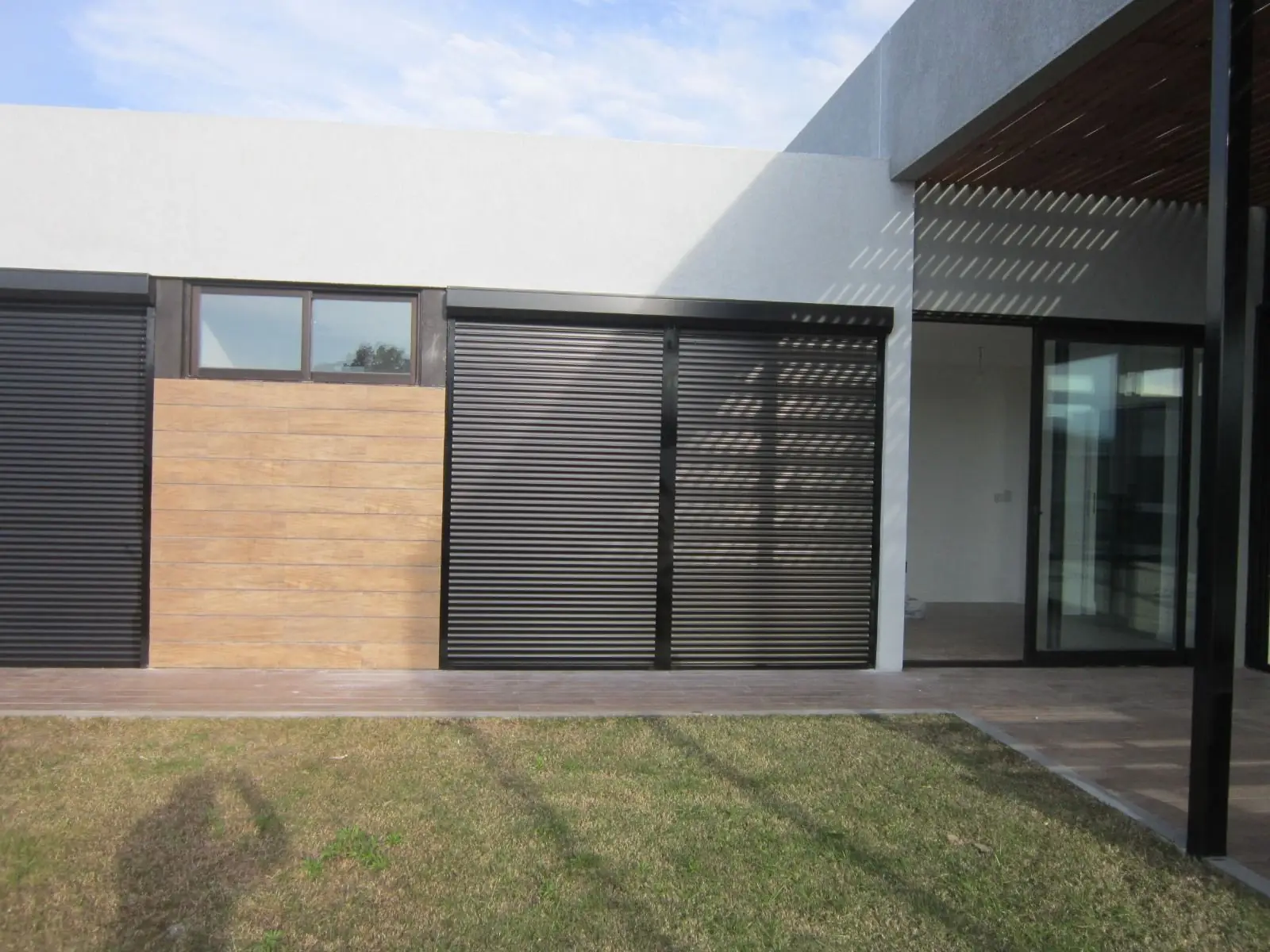 Casa moderna con cortinas de enrollar de aluminio en los ventanales