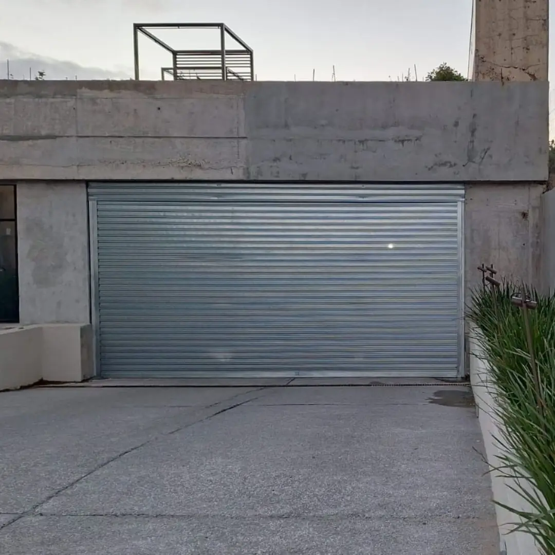 Cortina metálica de acero galvanizado cerrando la entrada de un garaje