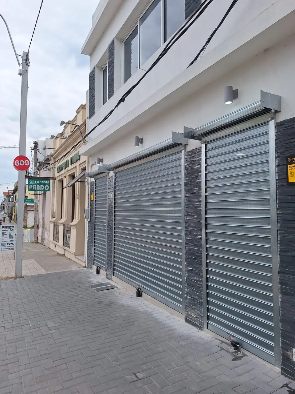 Dos cortinas metálicas en el frente de un local sobre la vereda