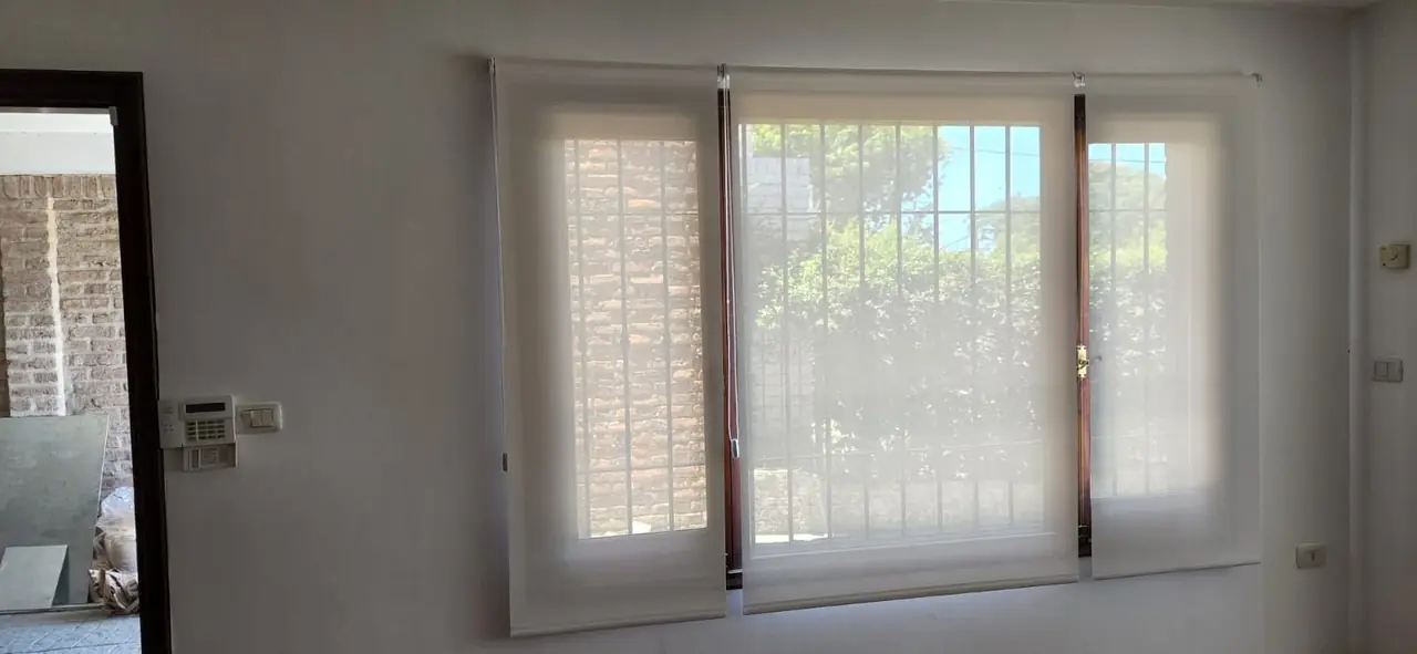 Cortinas roller screen blancas en dos ventanas de un living