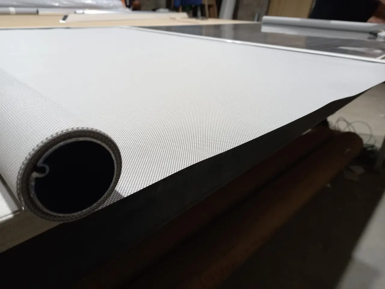 Tela de cortina roller cortada a medida sobre la mesa del taller